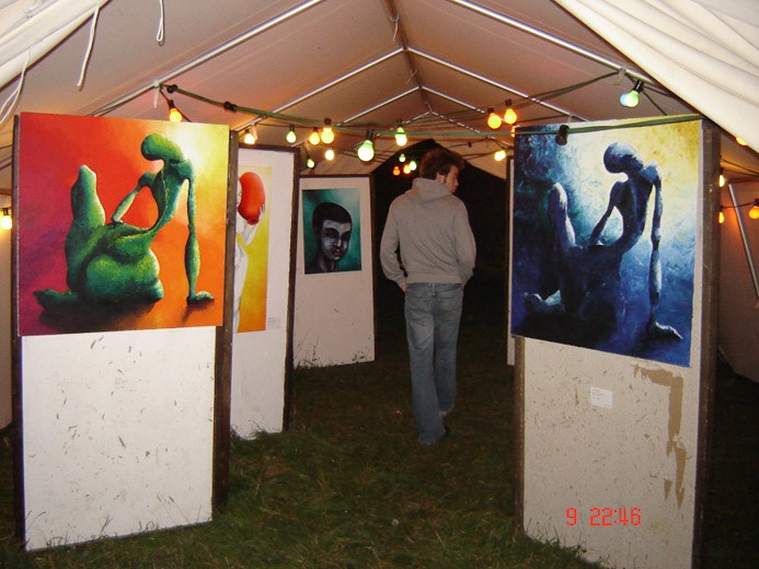 Ausstellung mit farbigen Gemälden in einem Veranstaltungszelt