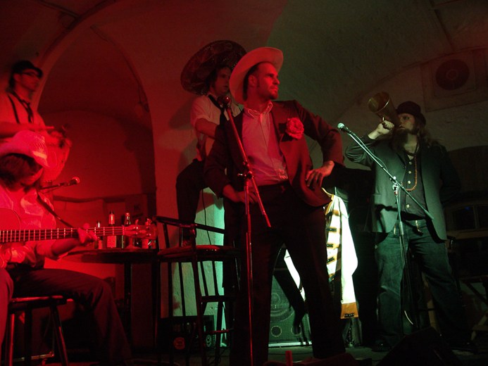 Mehrköpfige Band spielt im rot beleuchteten Gewölbe